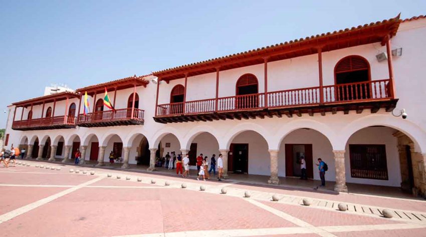 Fotografía de la fachada de la Alcaldía de Cartagena, con paredes blancas y techos cafés.