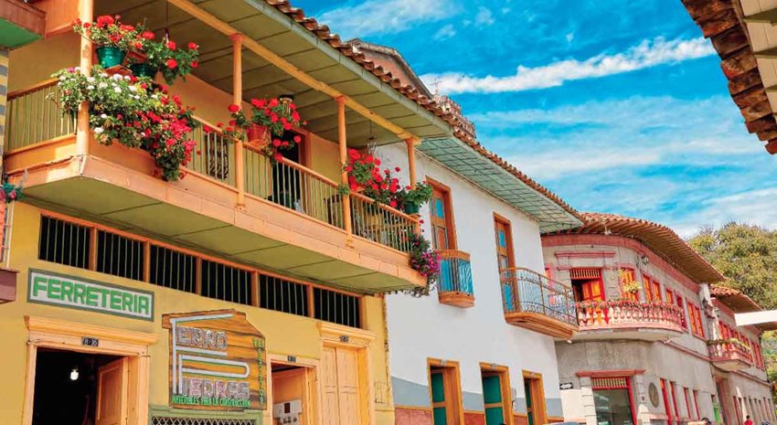 Fotografía de fachadas de casas coloridas, de dos pisos y con balcones.