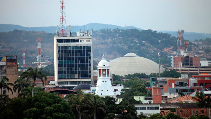 Foto panorámica de Cúcuta, enfocada en un domo, la torre de una iglesia y un edificio.