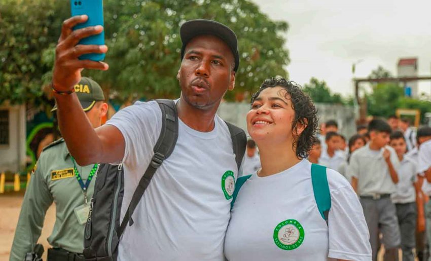 Hombre y mujer, con camisetas blancas, tomándose una selfie.