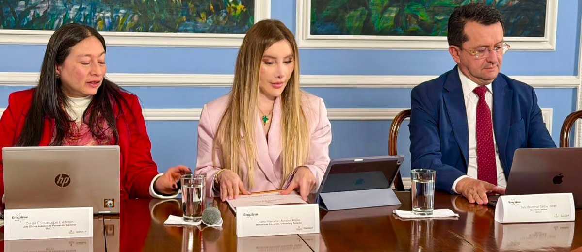 Descripción imagen: Ministra Diana Morales, sentada junto a su equipo de trabajo del Ministerio, mientras habla sobre el empalme.