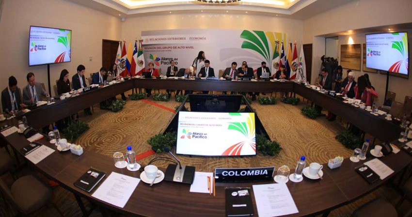 Funcionarios de los países que conforman la Alianza del Pacífico, sentados en una mesa dialogando.