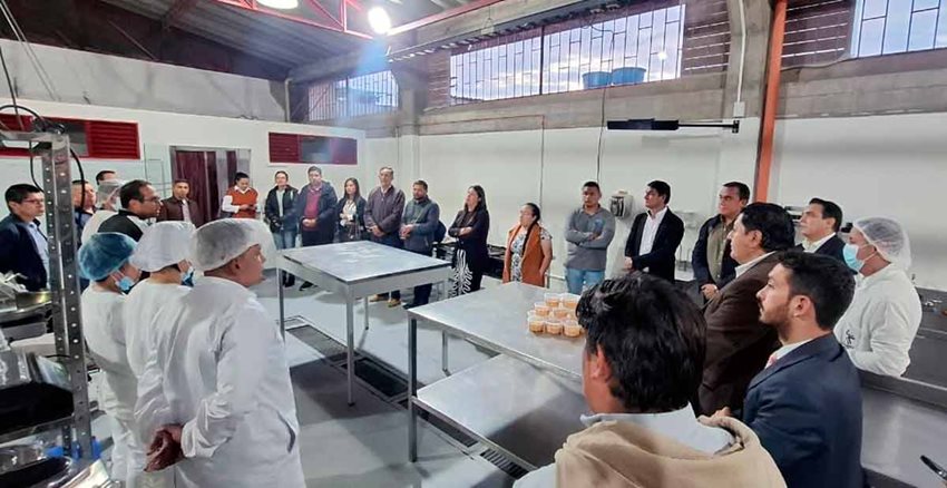 Personas reunidas dentro de las instalaciones de una fábrica de alimentos.