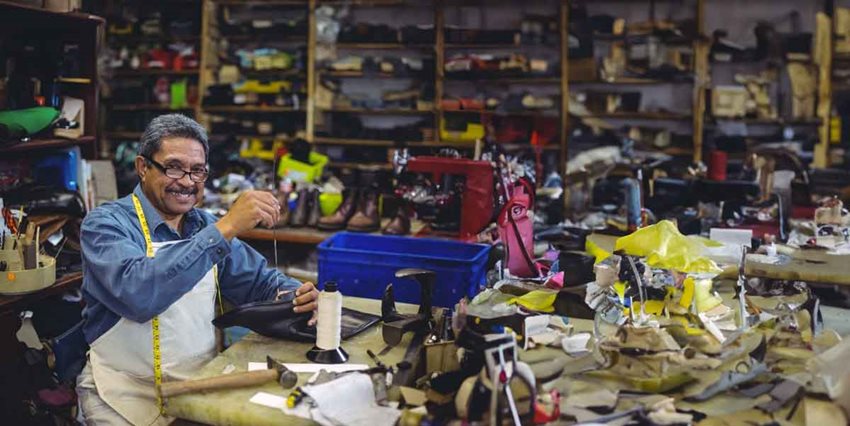 Hombre trabajando en taller de zapatos.