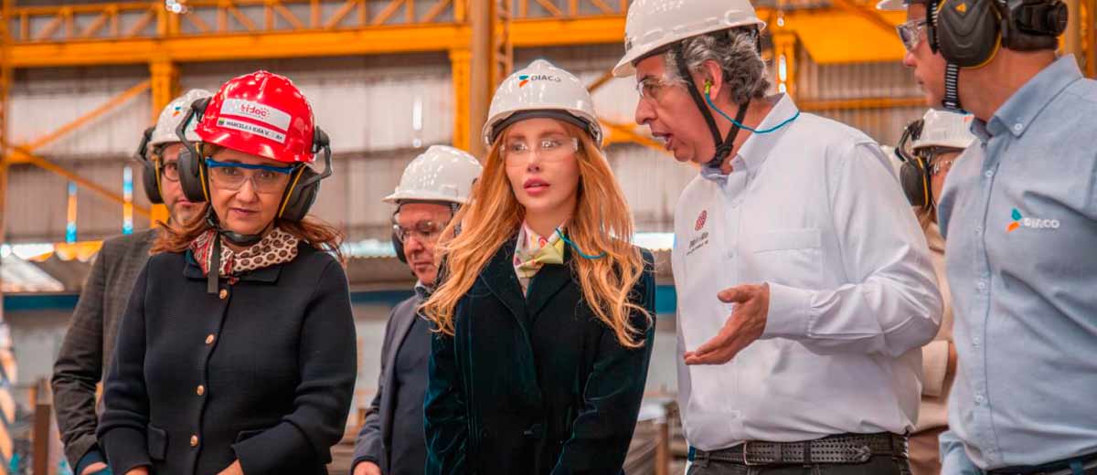 Descripción imagen: Ministra Diana Morales, con elementos de seguridad, caminando por fábrica.