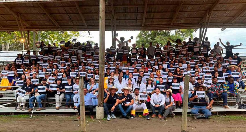 Hombres y mujeres sentados y posando para la foto con sus diplomas en las manos.