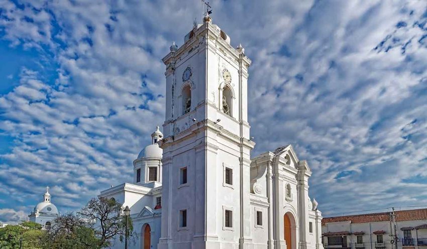 Fotografía de iglesia gris, en medio del parque.
