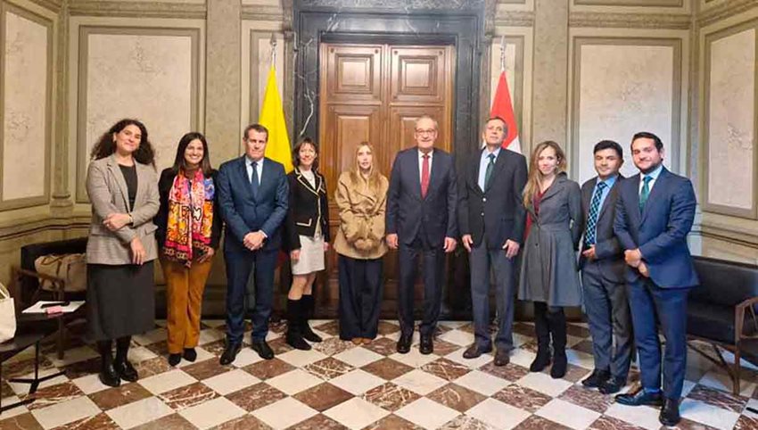 Hombres y mujeres de pie, en salón de gobierno, posando para la foto.