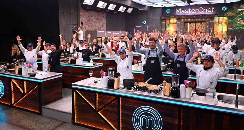 Hombres y mujeres con delantales de cocina, cocinando en instalaciones del programa gastronómico MasterChef.