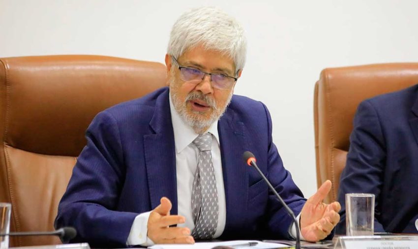 Ministro Germán Umaña, vestido de traje, hablando por micrófono al público.