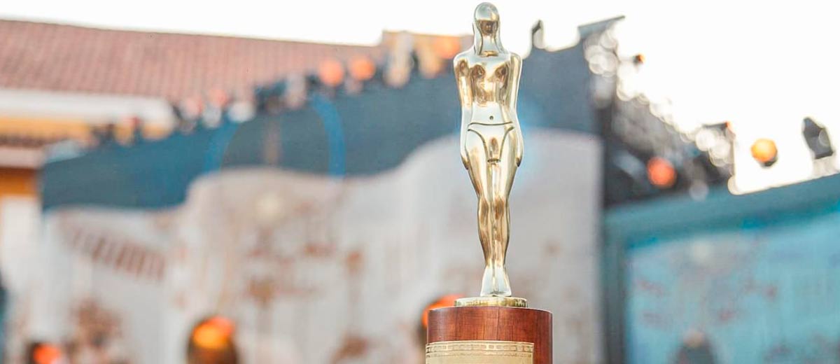 Descripción imagen: Estatuilla de los Premios India Catalina sobre una mesa, con fondo del mismo evento de día.