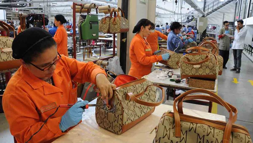 Mujeres confeccionado bolsos en medio del taller.