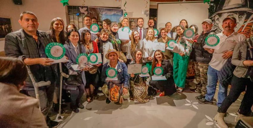 Hombres y mujeres posando para la foto con el sello 