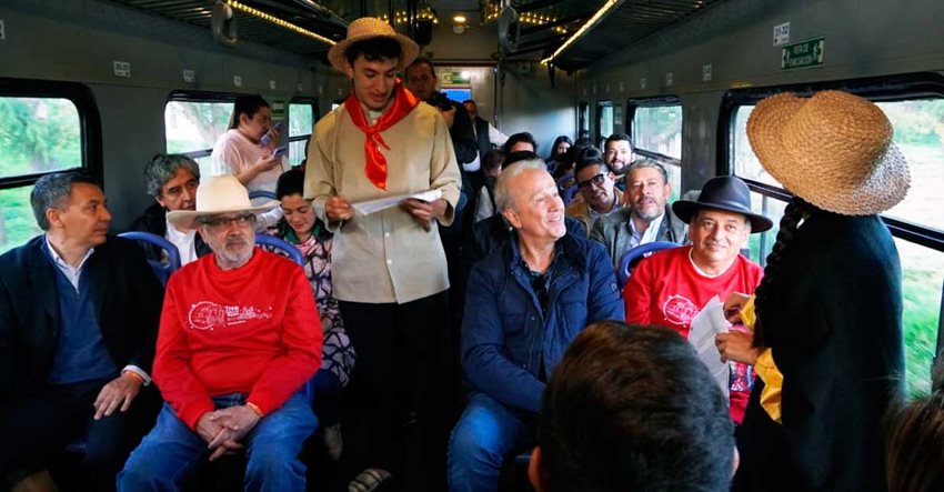 Hombres y mujeres sentados en sillas de tren, mientras este anda.