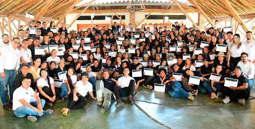 Muchas personas posando para la foto con diplomas en mano.