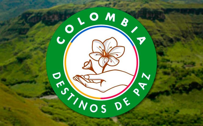 Imagen de montañas y sobre esta el sello de Colombia: destinos de paz, alusivo a una mano sosteniendo una flor