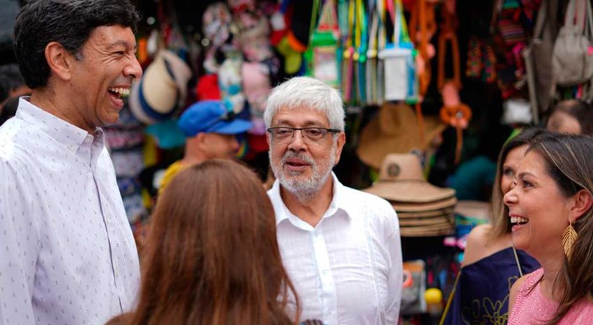 Ministro Germán Umaña hablando con personas frente a un puesto de artesanías.