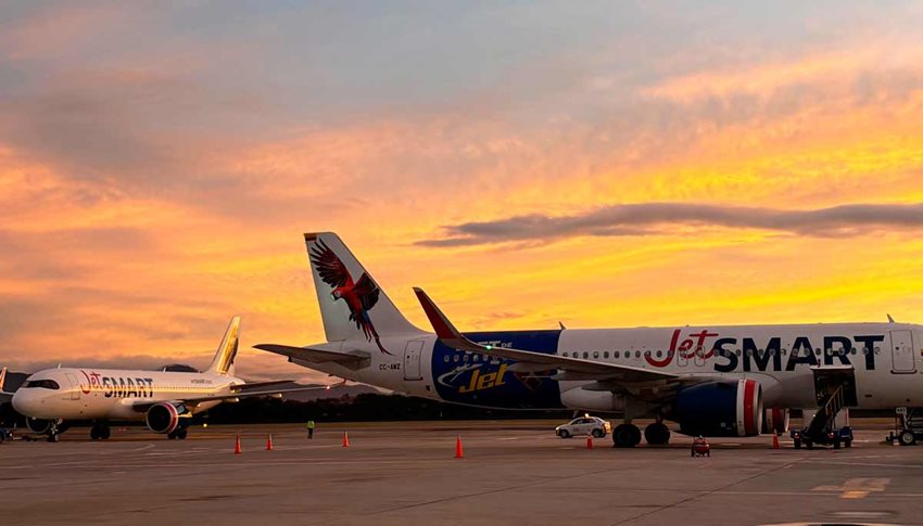 Aviones parqueados en pista aérea y detrás un atardecer.