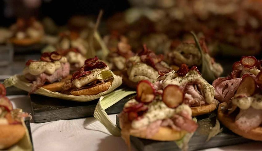 Comida típica colombiana servida sobre hojas y tablas.