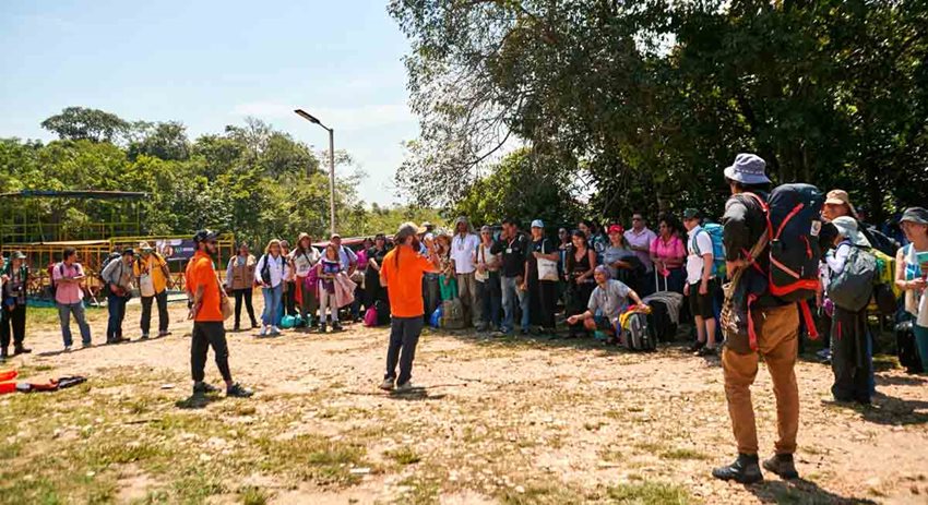 Personas reunidas alrededor de dos capacitadores, en medio del campo en el día.