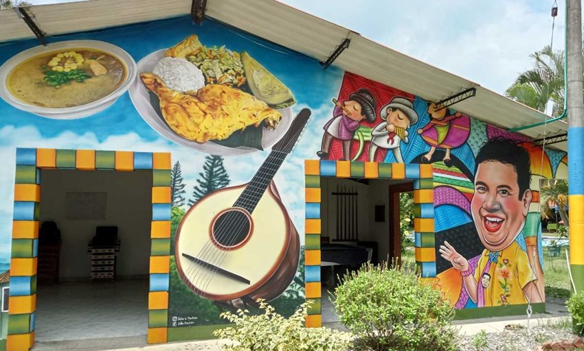 Fachada de casa pintada con instrumentos, comida y personajes típicos de Colombia, en Ginebra, Valle del Cauca