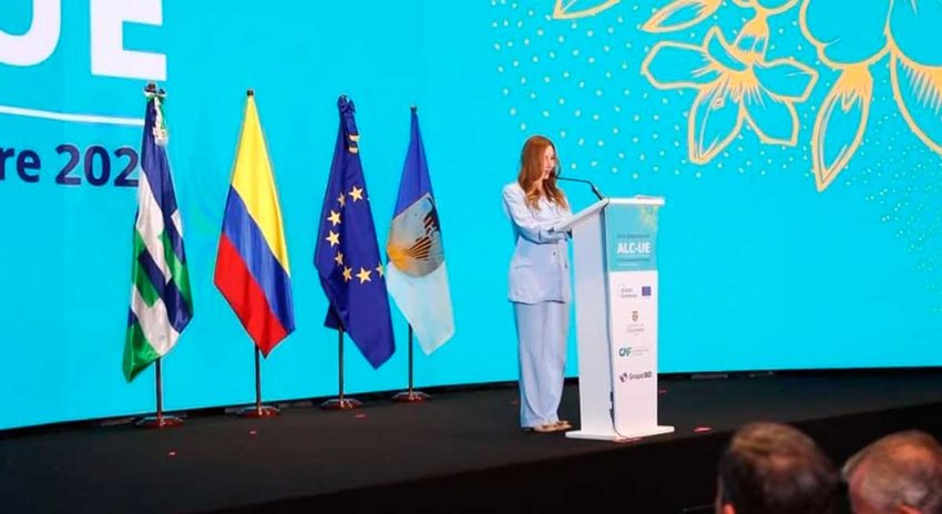 Ministra Diana Morales hablando desde el escenario, por micrófono, al público asistente.