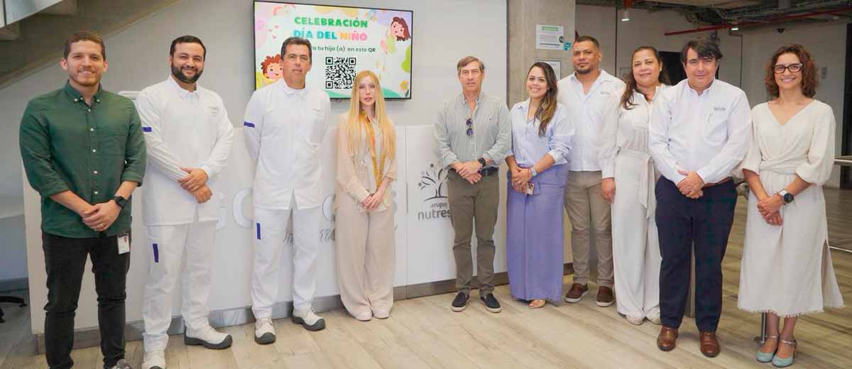 Descripción imagen: Ministra Diana Morales, vestida de blanco, posando para la foto junto a seis hombres y tres mujeres.