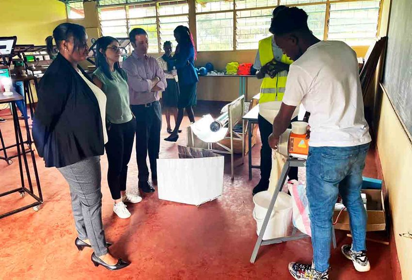 Tres personas viendo exponer a un hombre joven.