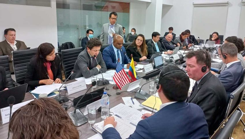 Funcionarios del Gobierno de Colombia y de Estados Unidos sentados en una mesa dialogando.