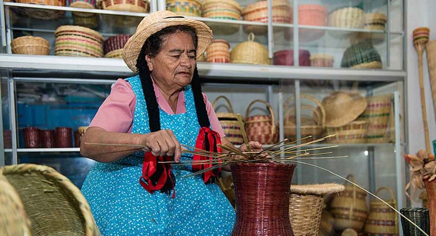 Mujer campesina tejiendo canastos.