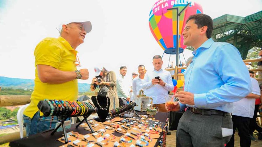 Ministro Luis Carlos Reyes hablando con vendedor de pulseras.