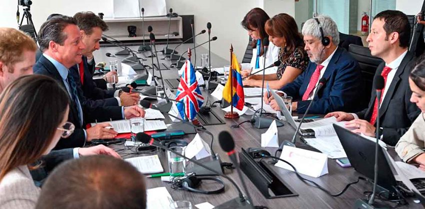 Funcionarios de los gobiernos de Reino Unido y Colombia dialogando en reunión.