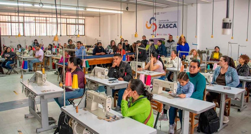 Personas sentadas frente máquinas de coser.