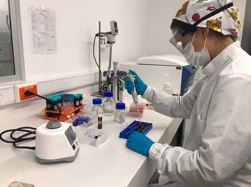 Mujer con todo su equipo tomando muestras en un laboratorio.