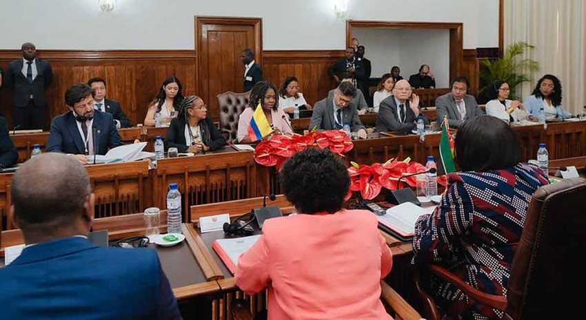 Hombres y mujeres, reunidos en un gran salón, dialogando.