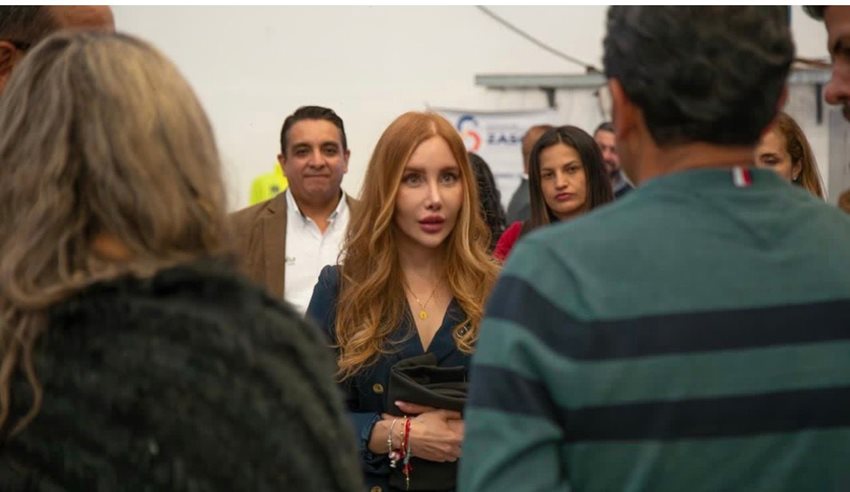 Ministra Diana Marcela Morales hablando con personas en medio de una reunión.