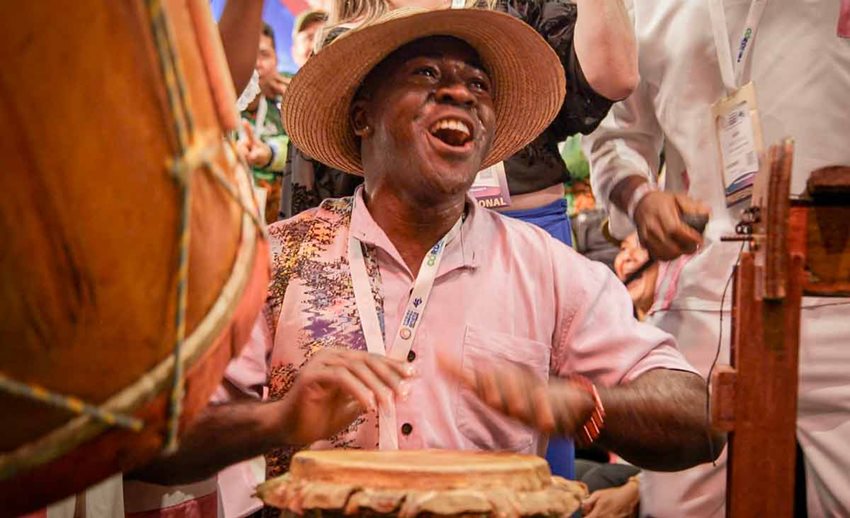 Hombre moreno tocando feliz tambores.
