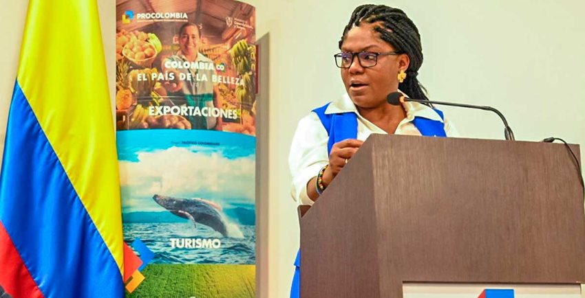 Vicepresidenta Francia Márquez hablando desde un atril al público, con una bandera de Colombia al lado.