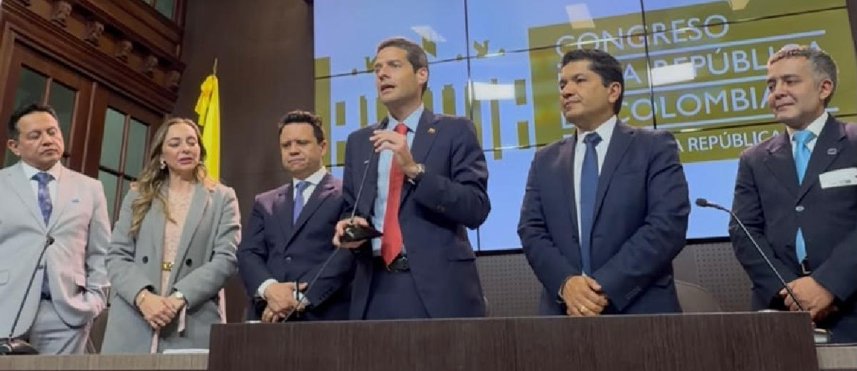 Descripción imagen: Ministro Mauricio Gómez Amín hablando a las personas, mientras está rodeado de hombres y una mujer de traje.