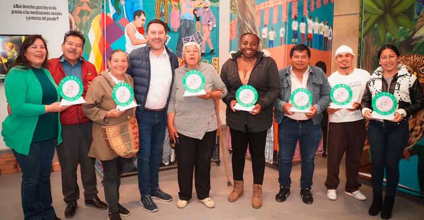 Viceministro Arturo Bravo posando para la foto con mujeres y hombres que sostienen el sello Destinos de Paz.