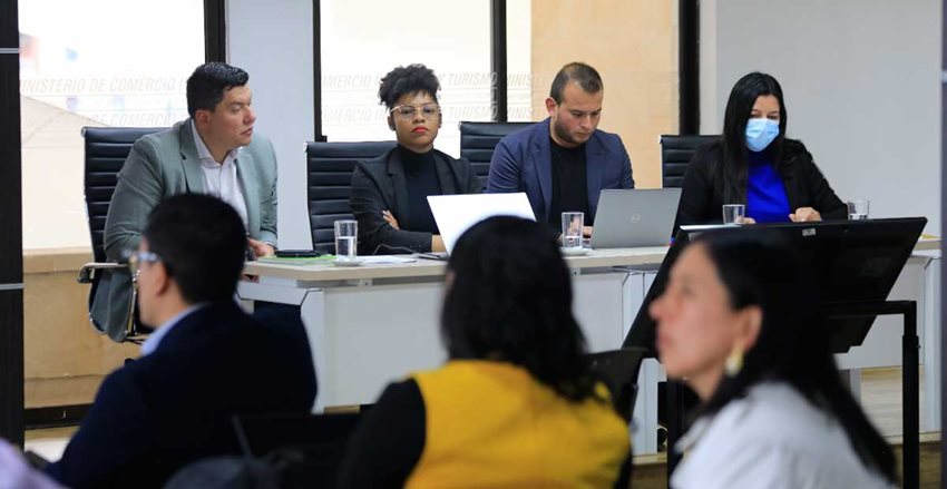 Dos hombres y dos mujeres ubicados en una mesa y liderando desde allí una conversación con el público.