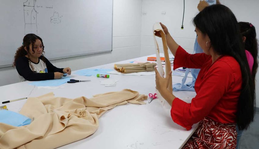 Tres mujeres en taller de costura.