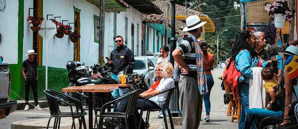 Descripción imagen: Turistas en medio de una calle de un pueblo, de día.