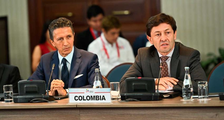 Dos hombres, con traje, hablando a las personas por micrófono.