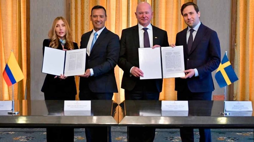 Ministra Diana Morales junto a tres hombres del alto Gobierno colombiano y sueco sosteniendo documentos.