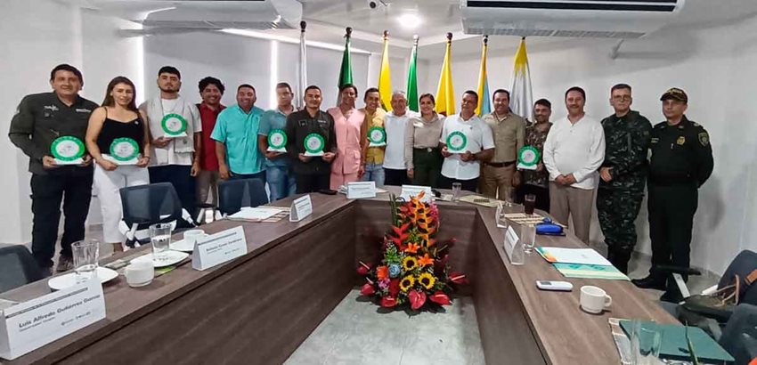 Hombres y mujeres, con el sello Colombia Destino de Paz en las manos, posando para la foto.