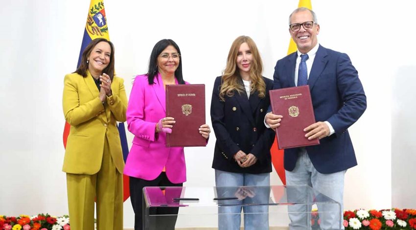 Tres mujeres y un hombre, de traje, posando para la foto, con documentos en las manos.