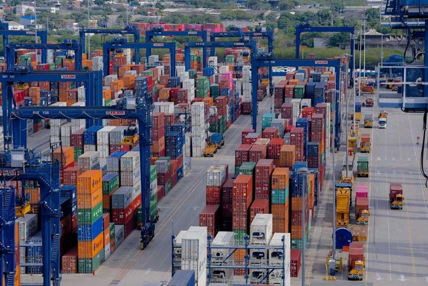 Puerto con muchos contenedores listos para exportar y cargados en caminones.