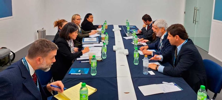 Personas sentadas alrededor de una mesa dialogando.