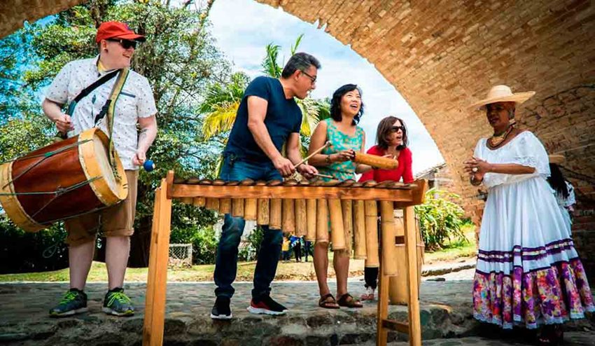 Cuatro turistas tocando instrumentos típicos de Colombia.
